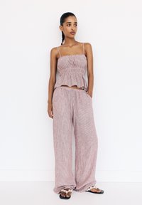 Two-piece outfit with a striped, lightweight peplum top and matching wide-leg pants. The fabric is textured, in soft pink tones with a drawstring waist.