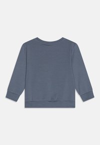 Sweatshirt en polaire gris avec un col rond, des manches longues et des poignets côtelés. Texture lisse avec une couleur unie et un design simple.