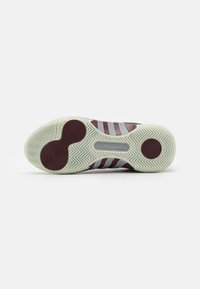 Schoenen zool in wit rubber met rode accenten. Heeft een visgraatpatroon, cirkelvormige details en meerdere rode en witte strepen over het ontwerp.
