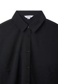 Blusa nera realizzata in tessuto morbido con colletto classico, bottoni frontali e un design minimalista senza motivi o accenti visibili.