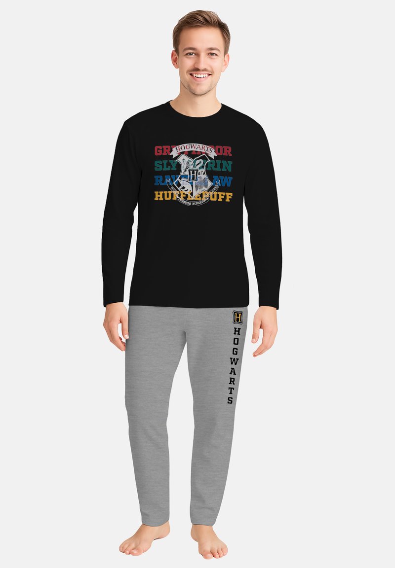 Schwarzes Langarmshirt mit dem Schriftzug "Hogwarts" und den Namen der Häuser in buntem Text, kombiniert mit grauen Trainingshosen, die mit "Hogwarts" geprägt sind.