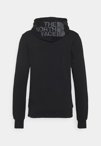 Sweat à capuche noir avec un design texturé et un grand logo gris au dos, des manches côtelées et une coupe décontractée.