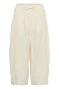 Pantalon ample couleur crème à jambes larges et courtes, avec une taille élastique et un lien à nouer à l'avant.
