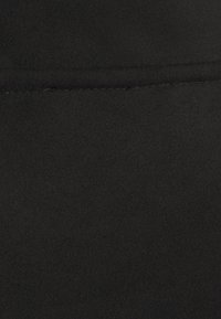 Tela de ante negra con una textura suave, que presenta una costura fina a lo largo del borde y un acabado liso y mate.