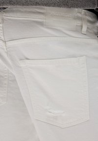 Jeans de denim alb cu un buzunar posterior ușor desfăcut. Talie cu un eticheta albă Pull&Bear, cu un finisaj elegant, texturat.