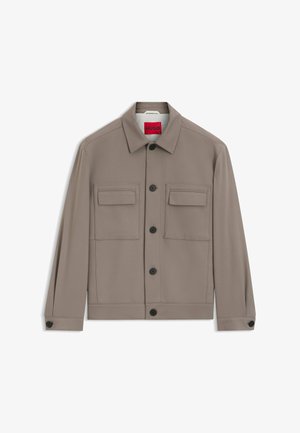 Chaqueta de hombre color topo con botones, dos bolsillos con solapa en el pecho, botones negros y cuello, mostrada sobre un fondo blanco.