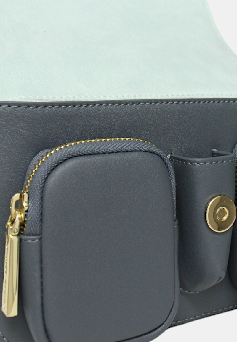 Borsa in pelle grigia con una parte superiore in suede azzurro chiaro, dettagli in cerniera dorata e chiusura a bottone con una piccola tasca laterale.