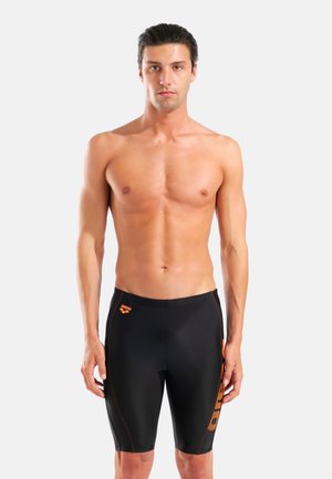 Sorte badeshorts med orange detaljer, lavet af strækbart, glat materiale. Har en tætsiddende pasform og et logo på øverste venstre side.