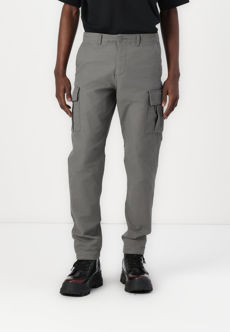 Pantaloni cargo gri cu buzunare laterale, fabricați dintr-un material durabil. Echipat cu închidere cu nasture și design cu picior drept. Asortați cu cizme negre.