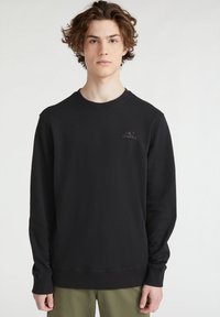 Sudadera negra de manga larga, con cuello redondo y un logo sutil en un tono más oscuro. Confeccionada en tejido suave, presenta puños y dobladillo acanalados.
