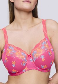 Rosa bh med blommönster i orange och blått. Har en scalloped spetskant och en central rosett. Mjukt, stretchigt material.