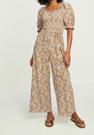 Buksedragt med blomsterprint i let stof, med firkantet halsudskæring, pufærmer og vidde ben i beige med sennepsaccent.