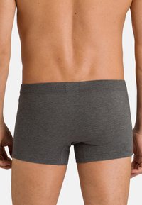 Harmaat puuvillaboksershortsit, joissa on istuva malli, sileä tekstuuri ja lyhyt pituus. Niissä on saumaton vyötärö ja ei näkyviä kuvioita.