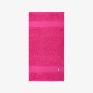 Rosa Badehandtuch mit strukturierter Oberfläche, versehen mit einem horizontalen Streifen und einem kleinen blauen Logo-Akzent in der unteren rechten Ecke.