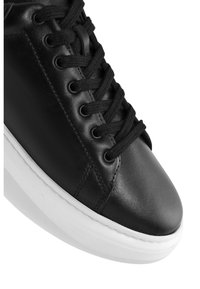 Sneaker in pelle nera con punta rotonda e suola in gomma bianca. Caratterizzato da lacci neri attraverso occhielli in metallo e dettagli di cucitura sottili.