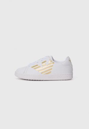 Hvit lav topp sneakers med gull Emporio Armani-logo på siden, snøring, og texturert såle mot en ensfarget hvit bakgrunn.