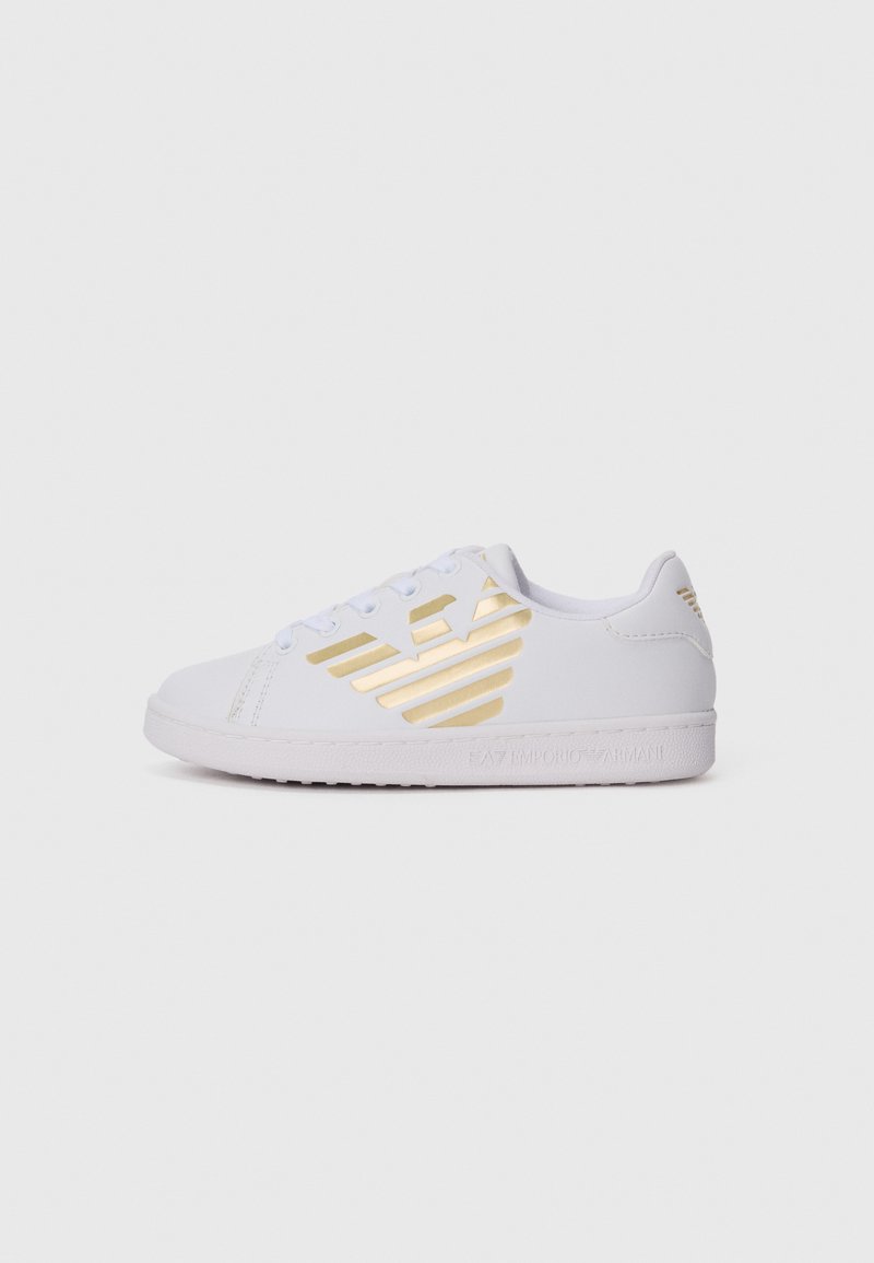 Hvit lav topp sneakers med gull Emporio Armani-logo på siden, snøring, og texturert såle mot en ensfarget hvit bakgrunn.