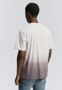 Korte mouw katoenen T-shirt met een ombre-gradiënt van licht crème naar donkergrijs; relaxte pasvorm en subtiele zijlogo-label.