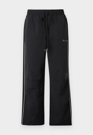 Svarte joggebukser med elastisk midje, hvite sidestrekker og to frontlommer. Har en logo og størrelsesmerke på siden.