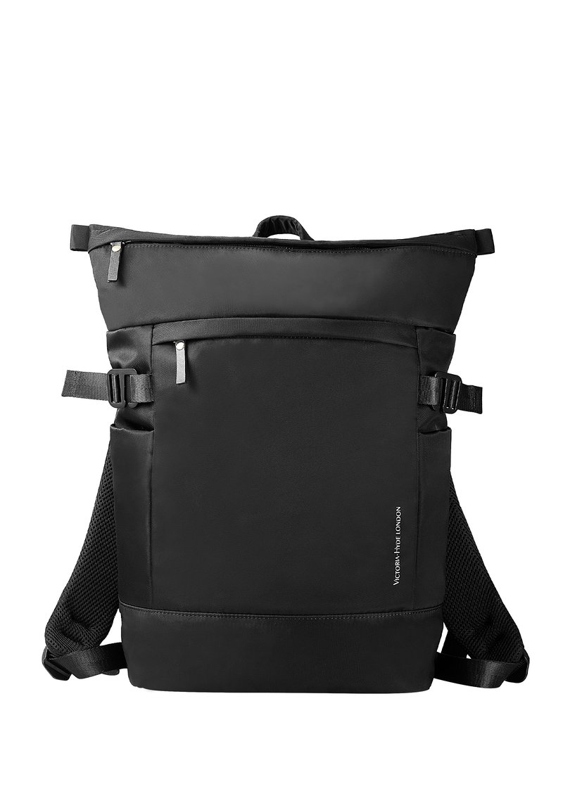 Sac à dos rectangulaire noir avec fermeture éclair sur le dessus, poche avant zippée, boucles latérales, bretelles en mesh et petit texte vertical sur le côté avant droit.