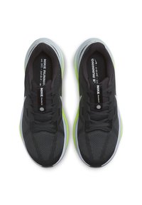 Zapatillas de running negras con parte superior de malla transpirable, acentos reflectantes y una suela verde vibrante. Presenta un diseño texturizado y cierre con cordones.