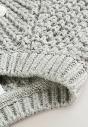 Chapeau en tricot gris clair avec un motif texturé et des bords côtelés. Fabriqué en fil doux, mettant en valeur des détails de tissage complexes.