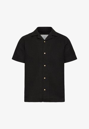 Černé tričko s krátkým rukávem vyrobené z texturované látky, s knoflíkovou přední částí, vystřiženým límečkem a světlými knoflíky.