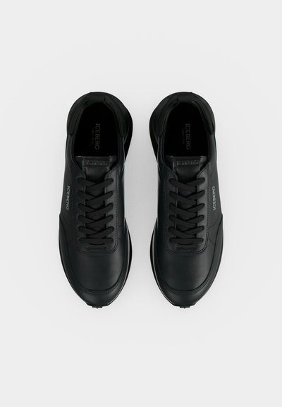 Paire de baskets en cuir noir avec lacets noirs et marquage Iceberg sur les côtés et la languette, vue de dessus sur fond blanc.