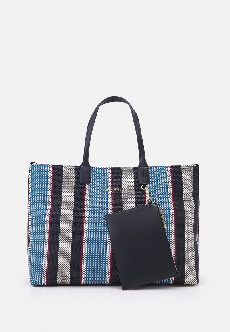 Tote-väska med ett strukturerat, vävt tyg med blå, röda och svarta ränder. Inkluderar en avtagbar svart blixtlåspåse.