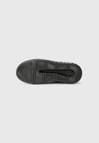 Black rubber shoe sole with textured patterns and raised accents. Features brand name "KARL LAGERFELD" embossed on the side.