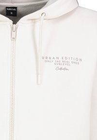 Weißer Reißverschluss-Hoodie aus weichem Material, mit einer Kapuze zum Zuziehen und bedrucktem Text in Grau: "URBAN EDITION NUR DIE ECHTEN SUBLEVEL."