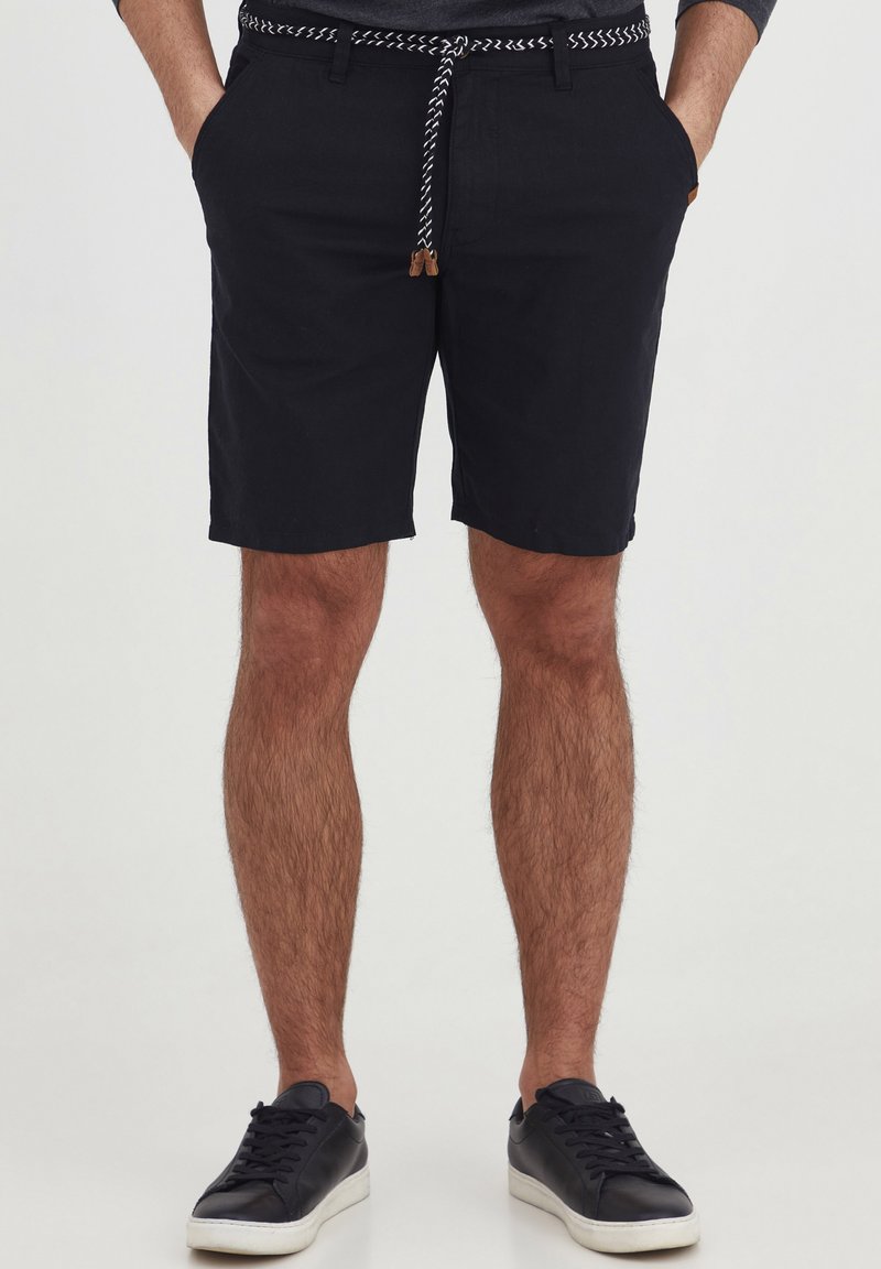 Black, knee-length shorts in cotton with a woven drawstring waistband featuring a contrasting pattern. Includes front pockets.