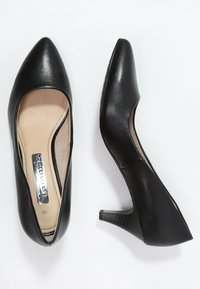 Svarta läderpumps med spetsig tå, snygg design och en liten blockklack, med en slät yta och minimala accenter.