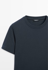 T-shirt bleu marine à manches courtes et col rond avec une étiquette de marque visible à l'intérieur du col.