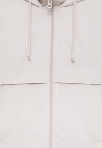 White zip-up jacket with drawstring hood, featuring a smooth texture, consistent color, and a horizontal seam across the chest.