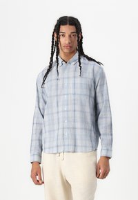 Blue plaid button-up shirt featuring a spread collar and long sleeves, made from a lightweight fabric, with a relaxed fit.