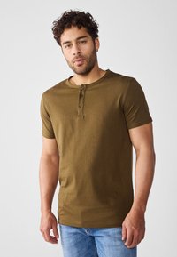 Tricou scurt cu maneci, de culoare verde olive, fabricat din bumbac, cu un guler rotund și un placket cu trei butoane; textură netedă și formă ajustată.