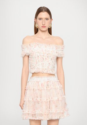 Off-the-shoulder top and matching tiered skirt made of sheer, floral-patterned fabric in pastel shades, featuring ruffled accents and smocked detailing.