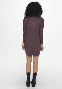 Maroon knit sweater dress with long sleeves, a rounded neckline, and a slightly tapered hem. Worn with black knee-high boots.