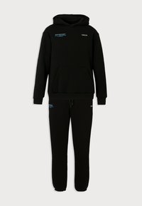 Zwarte hoodie met capuchon en kangoeroezak, gecombineerd met bijpassende joggingbroek, beide voorzien van kleine witte en blauwe tekstlogo's.