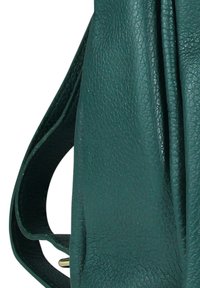 Gros plan sur un sac en cuir vert foncé texturé avec une sangle ajustable et une boucle dorée visible.