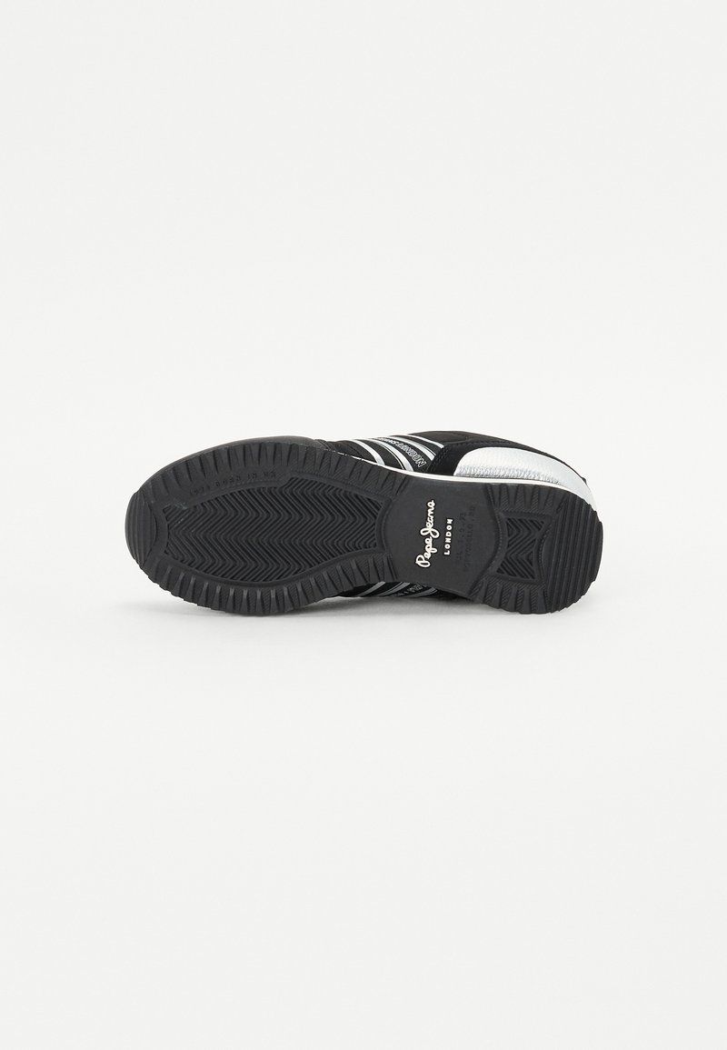 Vue du dessous d'une sneaker noire avec une semelle en caoutchouc texturé, des rayures blanches et des détails de logo. Présente une pointe arrondie et un motif de semelle robuste.