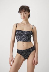 Μαύρο crop top με λουλουδάτο μοτίβο και αντίστοιχο κάτω μέρος μπικίνι. Μαλακό ύφασμα, εφαρμοστή γραμμή, με ρυθμιζόμενους ιμάντες και διακριτικές πιετές λεπτομέρειες.