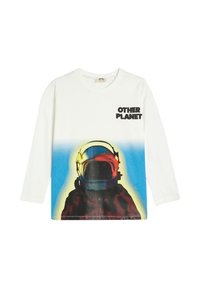 Pitkähihaisessa valkoisessa puuvillapaidassa on astronauttikuva, jossa on sinisiä ja oransseja yksityiskohtia sekä musta teksti "MUU PLANETTI".
