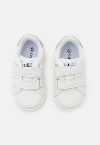 Witte leren schoenen met twee klittenbandsluitingen, ronde neus, gewatteerde kraag en rubberen zool. Het interieur heeft een gegraveerde binnenzool.