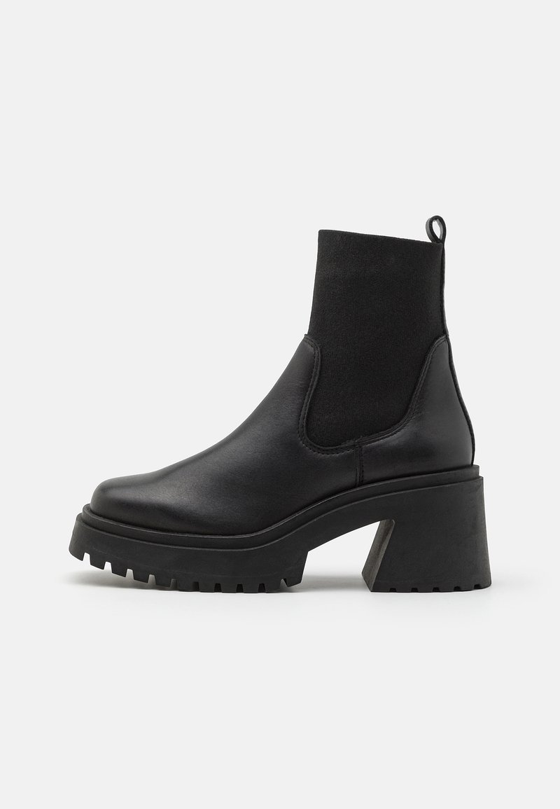 Černé kotníkové boty s hladkým koženým povrchem, elastickými bočními panely, robustním podpatkem a texturovanou gumovou podrážkou.