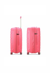 Pink hard-shell suitcase with textured surface, double zippers, retractable handle, and four wheels for easy mobility.