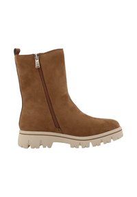 Bruine suede enkelboot met een zijrits, een chunky lichtgekleurde zool en een soepele textuur, met een ronde neus en minimale details.
