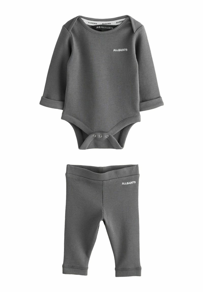 Šedý bavlněný dvoudílný outfit, který zahrnuje body s dlouhým rukávem a zapínáním na patentky a odpovídající legíny s jemnou texturou.