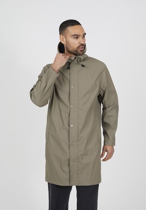 Manteau de pluie long en olive clair avec capuche, fermeture à boutons-pression à l'avant, poignets élastiques et poches latérales, présentant une texture lisse et imperméable.